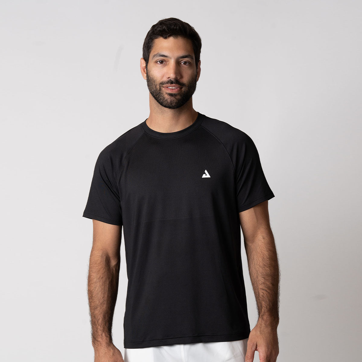 Gray background, image of a male model wearing the JOOLA Men's Court Short Sleeve shirt, black.