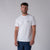 Gray background, image of a male model wearing a JOOLA Men's Court Short Sleeve Shirt, white.
