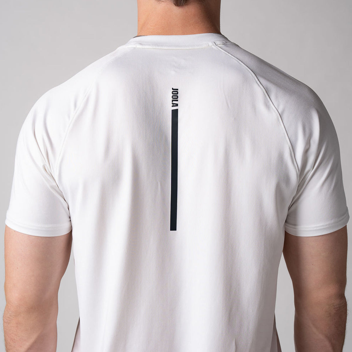 Close up image of the back of a JOOLA Men's Court Short Sleeve Shirt showing the JOOLA logo running down the center of the shirt.
