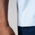 Gray background, close up on the raised JOOLA word mark tag on the side of the JOOLA Men's Club Short Sleeve, blue breeze.