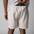 Close up image of the back of a pair of JOOLA men's club shorts, sandstone color.