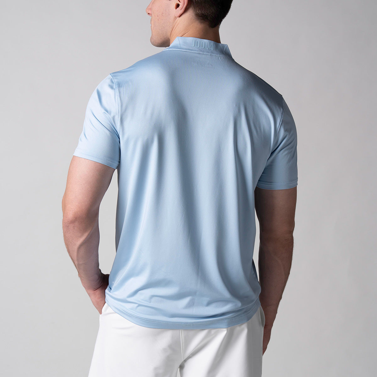 Gray background, image showing the back of a male model wearing the JOOLA Men's Court Polo, Blue Breeze.
