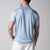 Gray background, image showing the back of a male model wearing the JOOLA Men's Court Polo, Blue Breeze.