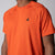 Gray background, close up image of the black trinity logo over the left chest of the JOOLA Men's Court Short Sleeve tee in poppy red.