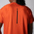 Gray background, image showing the back of a male model wearing a JOOLA Men's Court Short Sleeve tee in poppy red. The JOOLA logo is running vertically down the middle of the back of the shirt.