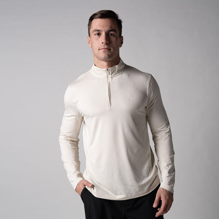 Gray background, male model wearing a JOOLA Men's Quarter Zip Pullover, sandstone color.