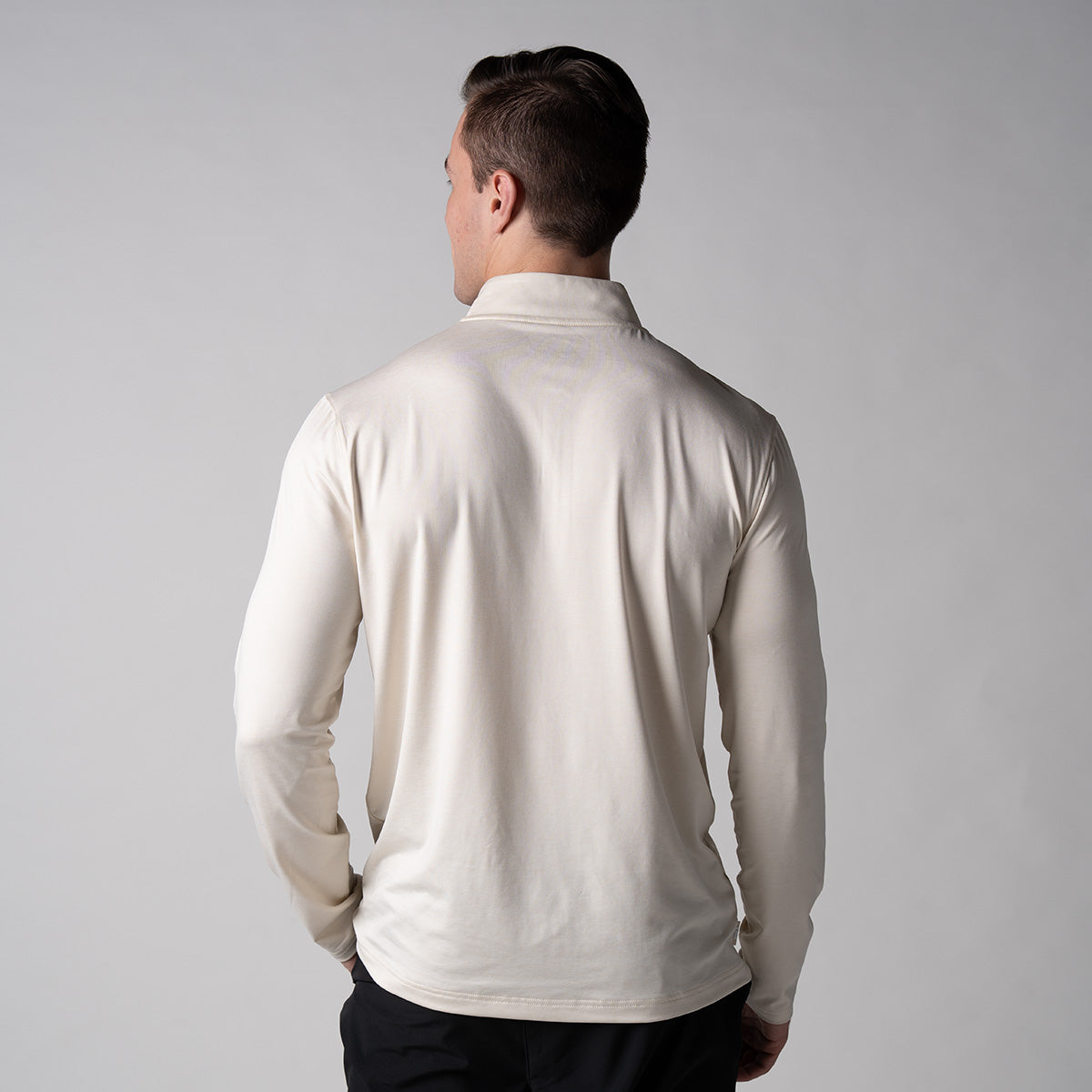 Gray background, image showing the back of a male model wearing a JOOLA Men's Quarter Zip Pullover, sandstone color.