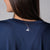 Detailed JOOLA Trinity logo on the back of a JOOLA Women's Court Crop Tee, Navy.