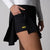 Gray background, close up on the leg of a female model to reveal the hidden under-shorty pocket and JOOLA word mark logo in yellow, black skirt.