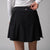 Gray background, close up image of the JOOLA trinity logo on the back of a JOOLA women's pickleball skort, black.