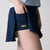 Gray background, close up image of a female model wearing the JOOLA women's pickleball skort, and revealing the hidden under-shorty pocket and yellow JOOLA word mark logo, navy.