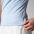 Gray background, close up on the raised JOOLA word mark logo on the JOOLA women's club short sleeve, blue breeze.