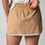 Gray background, close up image of a JOOLA women's club skort, latte and print.