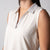 Gray background, close up image of the collar on a JOOLA women's club sleeveless polo, sandstone and print.