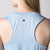 Gray background, close up image of a female model's back who is wearing a JOOLA women's court tank, blue breeze.