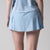 Gray background, close up image of the back of a female model wearing a JOOLA women's pickleball skort, blue breeze.