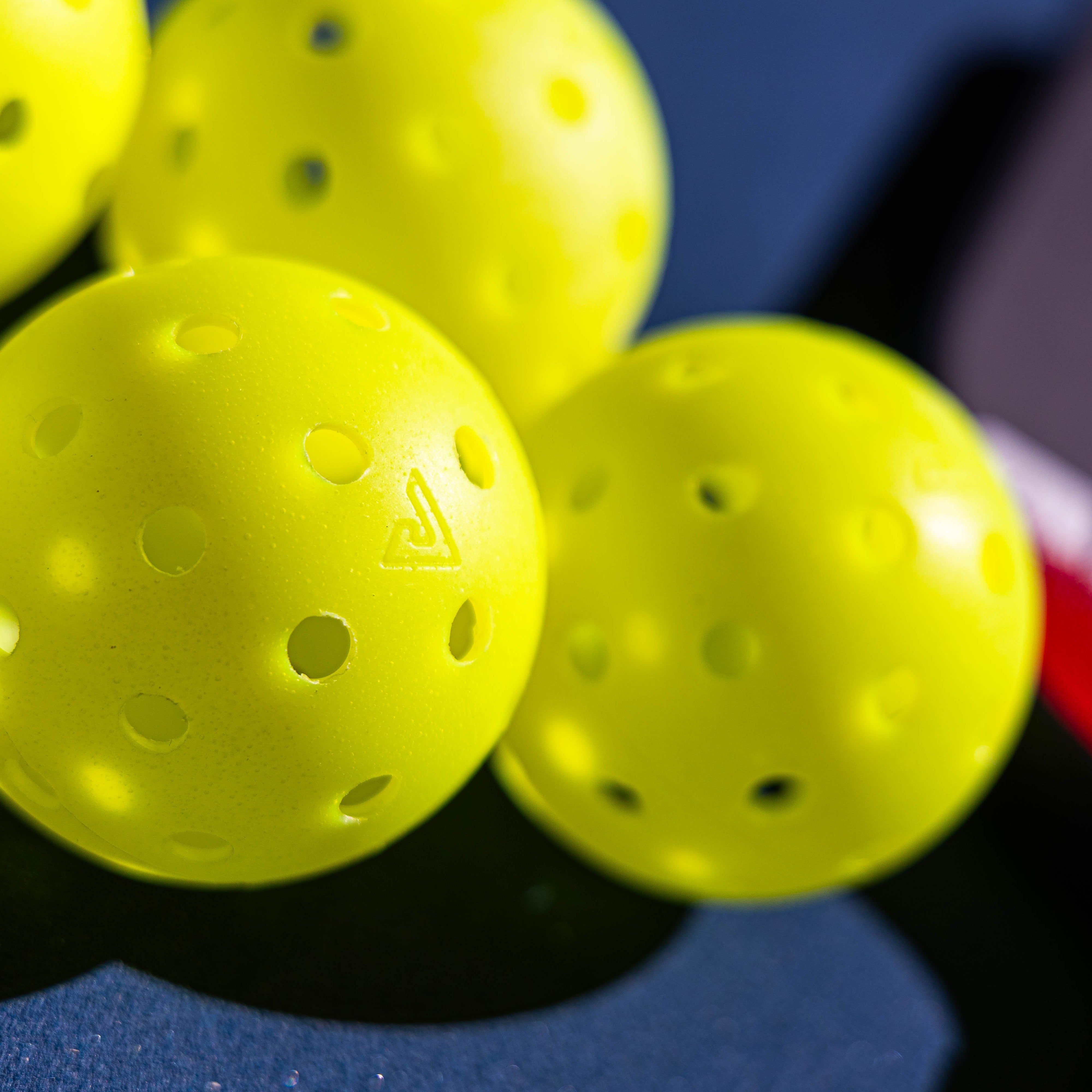 Close up image of four JOOLA HC-40 pickleballs.