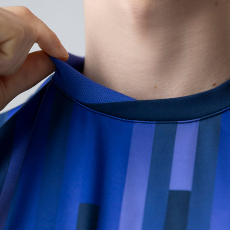 Close-up of a person wearing a blue JOOLA Table Tennis jersey.