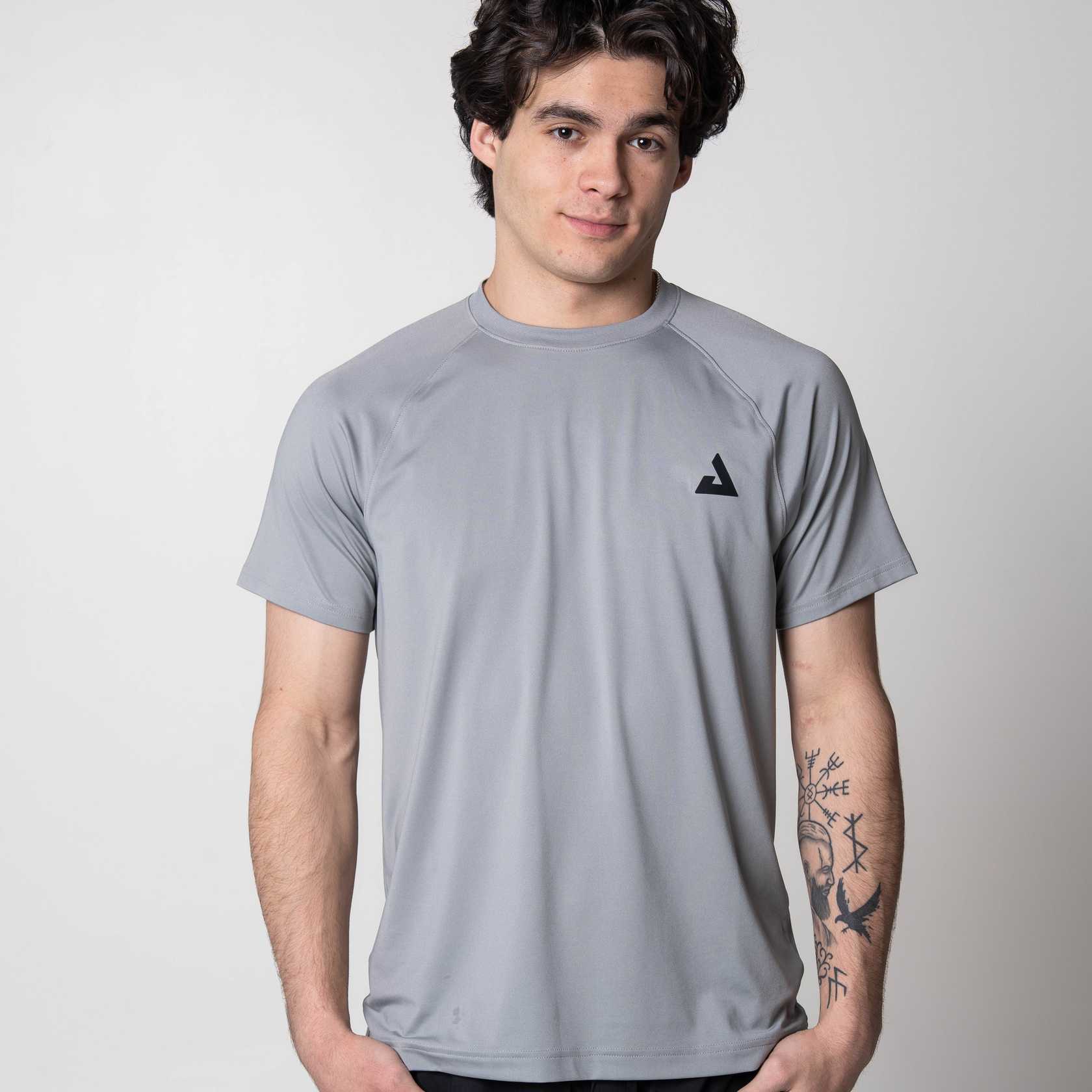 White background, image of a model wearing a gray JOOLA Court Short Sleeve shirt.