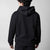 Gray background, image showing the back of a male model who is wearing the JOOLA Fleece Hoodie, Black.