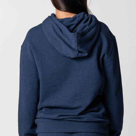 Gray background, image showing the back of a female model who is wearing a JOOLA Fleece Hoodie, Navy.