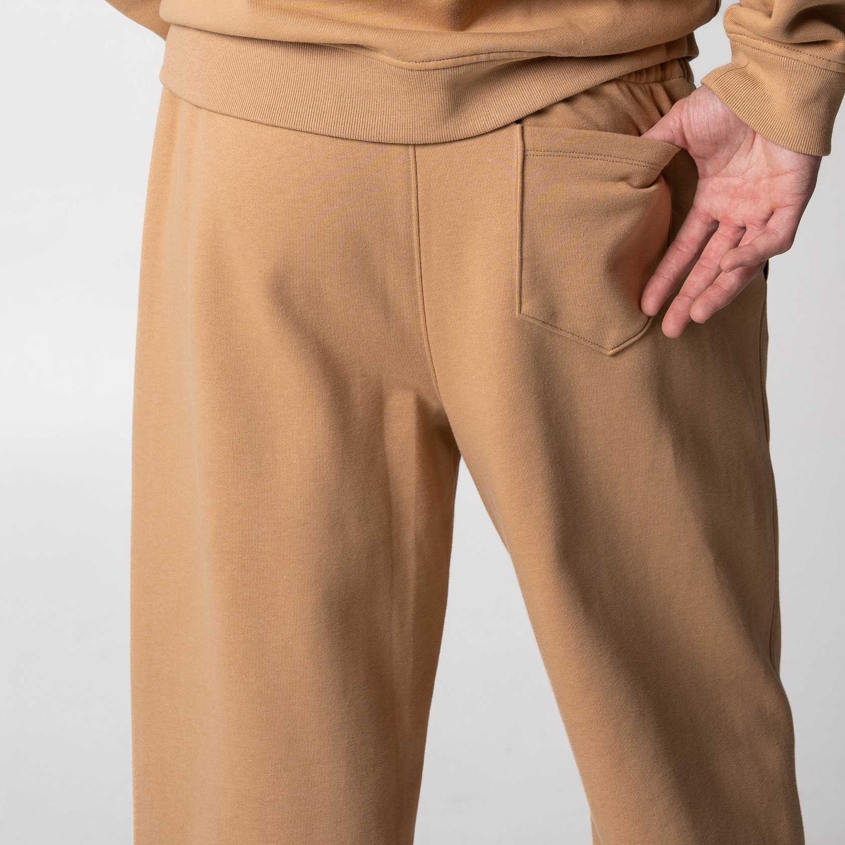 Gray background, image of the back pocket on a pair of JOOLA Fleece Pants, latte.