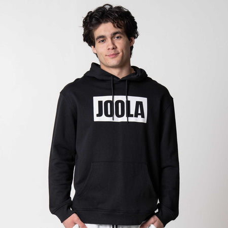 Gray background, image of a male model wearing a JOOLA Graphic Hoodie, Black and White.