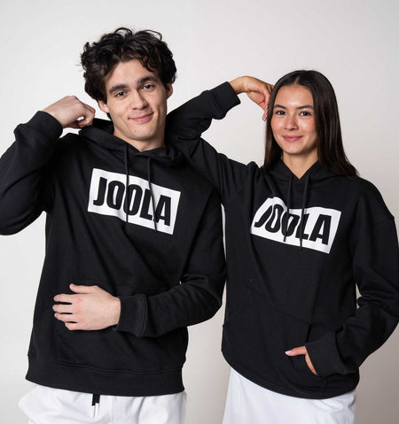 Two models posing in matching JOOLA Graphic Hoodies, Black and White.