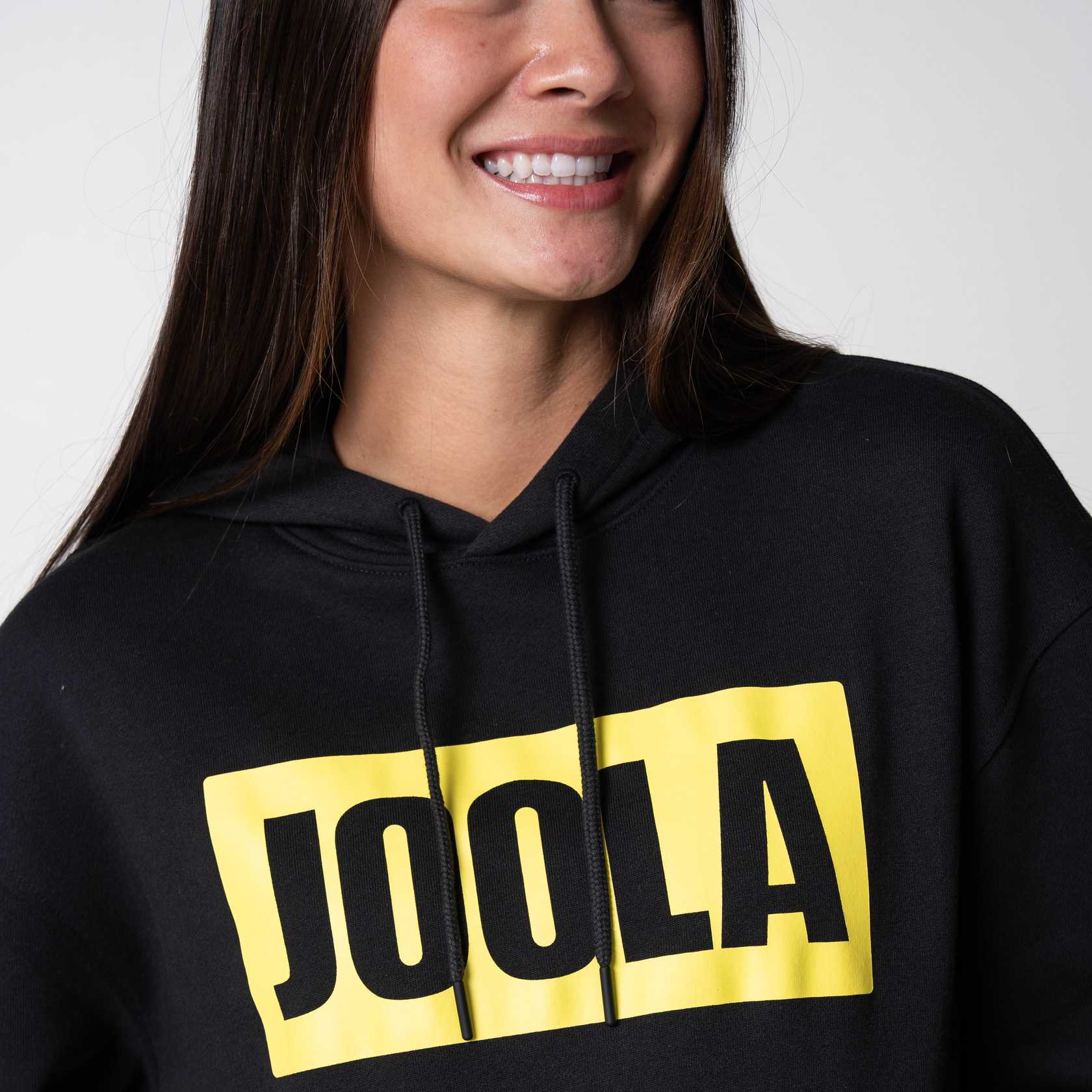 Close up on the yellow and black JOOLA logo on the front of a JOOLA graphic hoodie, black and yellow.