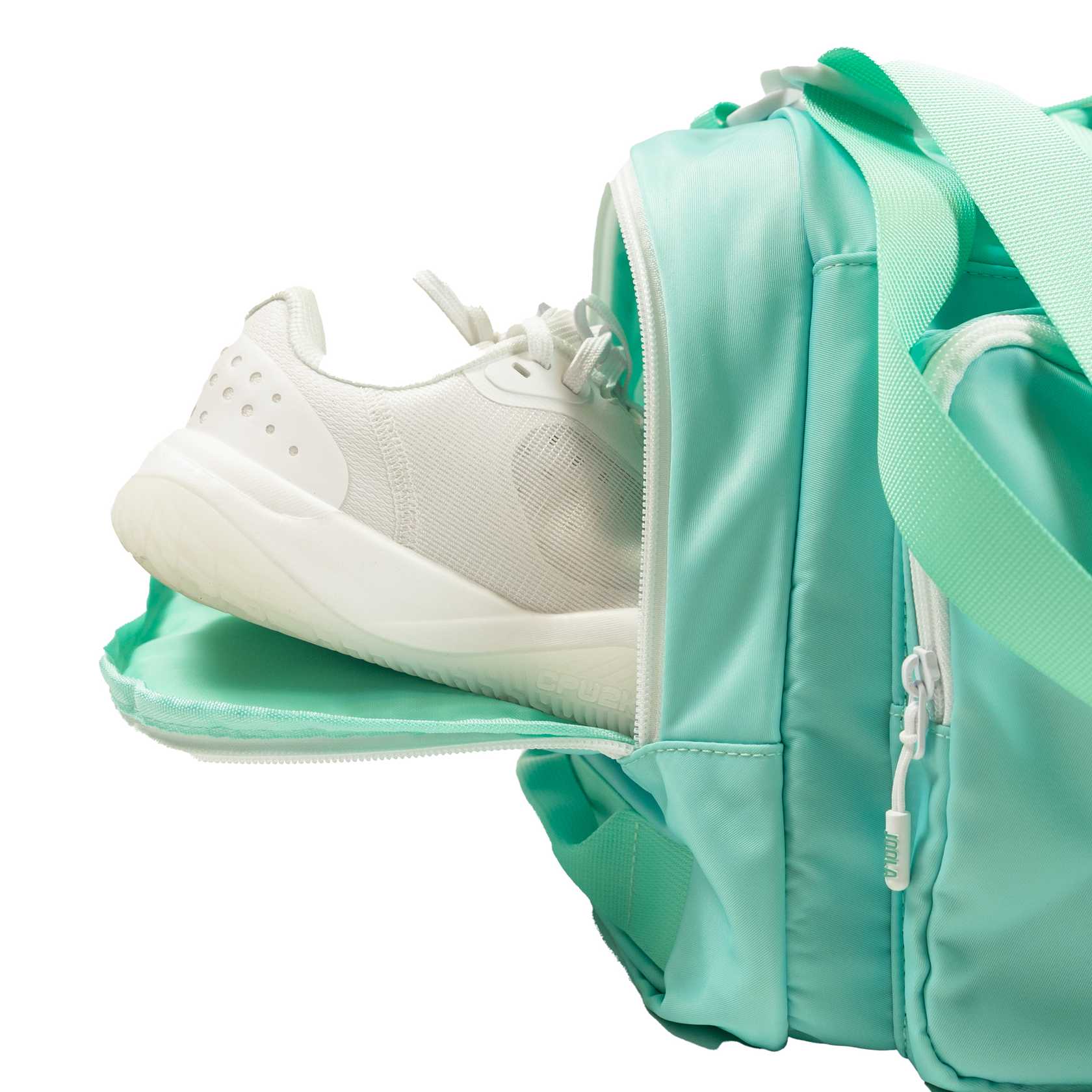 White background, close up image of a pair of shoes in the shoe compartment of the JOOLA duffle bag.