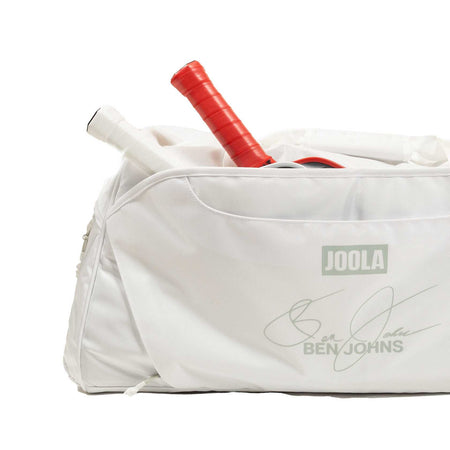 White background, close up image of the JOOLA Ben's Bag duffle with two pickleball paddles in the side pocket.
