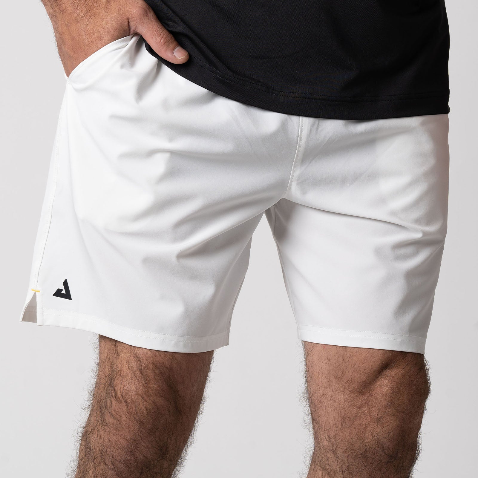 Close up image of a pair of JOOLA men's woven shorts, 7 inch inseam, white with black JOOLA trinity logo over the right leg.