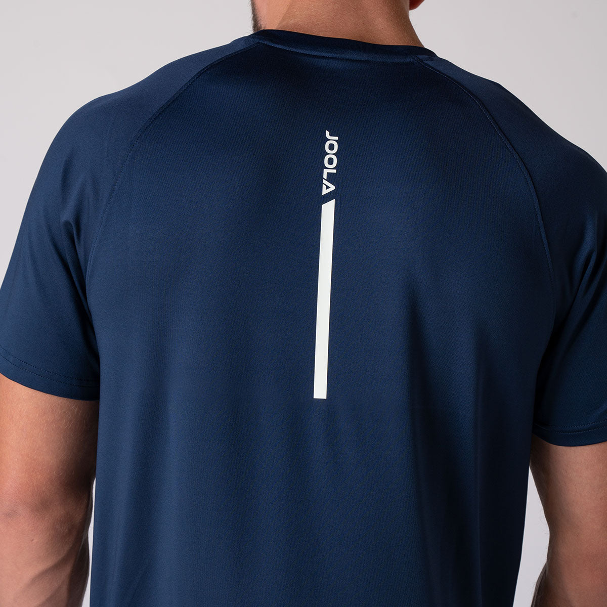 Close up image of the JOOLA logo that runs down the middle of the JOOLA Men's Court Short Sleeve shirt, navy.