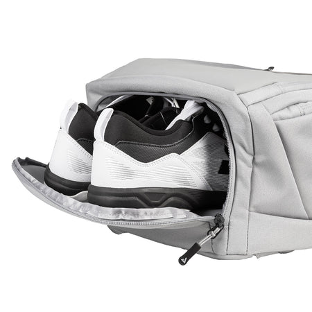 Gray shoe bag with a pair of black and white sneakers inside on a white background.