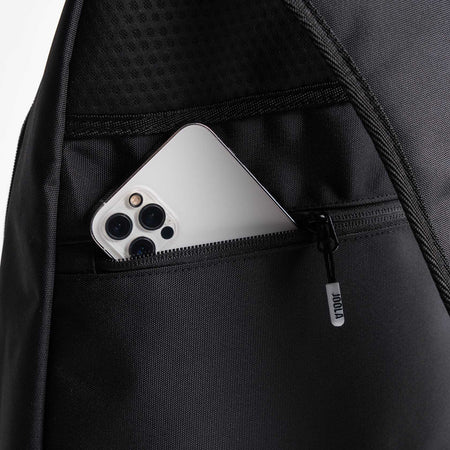 Close up image of a cell phone in the side pocket of a JOOLA Sling Bag, black.