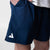 Close up on the white JOOLA trinity logo on the leg of a pair of Navy blue JOOLA Woven shorts, 7-inch inseam.